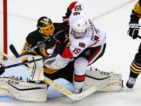 Ottawa Senators' Derick Brassard (19) collides with Pittsburgh Penguins goalie Marc-Andre Fleury (29).