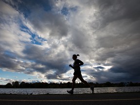 A runner makes her way along Dow's Lake under cloudy skies.