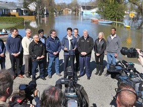 Prime Minister Justin Trudeau flanked by Mayor Maxime Pedneaud-Jobin, left, and Premier Philippe Couillard, talks to the media on Rue Saint-Louis in Gatineau after a helicopter tour of the flooded area. TONY CALDWELL / POSTMEDIA NETWORK