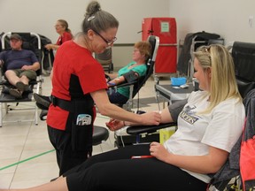 Karen Mathieson, from the Canadian Blood Services, prepares to collect blood from Brooke Vandersleen, 21, during a blood clinic at the East Elgin Community Complex in Aylmer Thursday. The national agency is looking for new people to sign up and donate their blood ahead of an expected decrease in donors due to the coming long weekend holiday. (JONATHAN JUHA, Times-Journal)