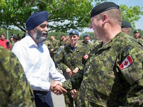 Defence Minister Harjit Sajjan talks with soldiers after announcing investments in infrastructure for the 5th Canadian Division Support Base at CFB Gagetown in Oromocto, N.B. on June 27, 2016. (THE CANADIAN PRESS/Andrew Vaughan/Files)