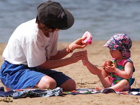 Spreading sunblock on the skin of children who are playing outside can decrease their risk of skin cancer later in life. (Postmedia Network file photo)