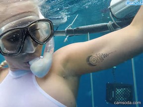 Cam girl Molly Cavalli is seen during a promo for CamSoda, where she goes shark diving. (YouTube screenshot)