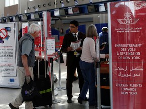 In this file photo dated Thursday, March 29, 2017, airport staff communicate with passengers at the check-in area at Casablanca Mohammed V International Airport, Morocco. (AP Photo/ Abdeljalil Bounhar, FILE)
