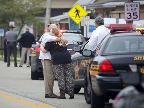 People hug as emergency personnel arrive to the scene of a shooting outside Pine Kirk nursing home in Kirkersville, Ohio on Friday, May 12, 2017. (Tom Dodge/The Columbus Dispatch via AP)