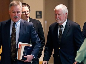 Arthur Peekel, centre, a former admissions officer at Phillips Exeter Academy, follows his lawyer Philip Utter, left, past reporters after appearing at a hearing at Rockingham County Superior Court in Brentwood, N.H., Friday, May 12, 2017. (AP Photo/Charles Krupa)