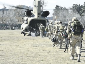 The last Canadians involved in the NATO training mission in Afghanistan board an American Chinook helicopter, on March 12, 2014, as they leave the International Security Assistance Force headquarters in Kabul, Afghanistan. (MCpl Patrick Blanchard/Canadian Forces Combat Camera file photo)