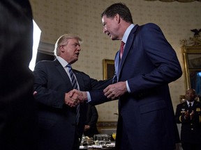 U.S. President Donald Trump (left) shakes hands with James Comey during an Inaugural Law Enforcement Officers and First Responders Reception in the Blue Room of the White House in Washington on Jan. 22, 2017. (Andrew Harrer/Pool/Getty Images)
