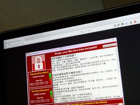 A screenshot of the warning screen from a purported ransomware attack, as captured by a computer user in Taiwan, is seen on laptop in Beijing, Saturday, May 13, 2017.  (AP Photo/Mark Schiefelbein)