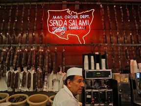 A sign advertising mail delivery is displayed at Katz's Delicatessen in New York, Thursday, May 11, 2017. The famed New York City restaurant that made a name for itself during World War II with the slogan "send a salami to your boy in the Army," is launching an expanded global delivery business that will allow people to ship its cured meats around the world. (AP Photo/Seth Wenig)
