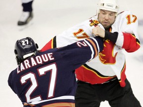 Calgary Flames’ Chris Simon (right) fights with Edmonton Oilers’ Georges Laraque Saturday April 1, 2006.