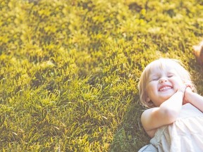 Smiling mother and baby laying on meadow