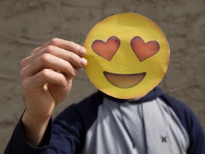 MacEwan University student Darcy Raymond holds an emoji as he poses for a photo at his home in Stony Plain Thursday May 11, 2017. Raymond recently completed a study that explores how emoji usage can affect perceived intelligence in an online dating context. Photo by David Bloom