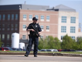 A Kane County police officer monitors the scene at Northwestern Medicine Delnor Hospital in Geneva, Ill., during a lockdown after a jail inmate being treated there managed to take a correctional officer's gun in the facility and hold an employee hostage, Saturday, May 13, 2017. (Chris Sweda/Chicago Tribune via AP)