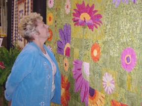 Cambridge resident Elizabeth Straus admires quilt entitled In Full Bloom at the Pieces of Magic show in Ingersoll Friday. (HEATHER RIVERS, Sentinel-Review)