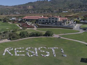 This Saturday, May 13, 2017, photo released by an organization known as Indivisible San Pedro shows protesters spelling out the word "RESIST!" at a public park nestled within Trump National Golf Course in Rancho Palos Verdes, Calif. The flash mob-style protest calls for a special prosecutor to investigate collusion by the Trump campaign with Russia's interference with the 2016 elections. (Indivisible San Pedro via AP )