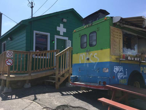 The owners of the little green marijuana dispensary on Laperriere Avenue tucked behind a chip truck have been given a court summons for violating zoning laws.