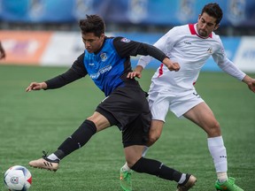 Dustin Corea of FC Edmonton, is slowed by Tyler Gibson of the San Francisco Deltas at Clark Field in Edmonton on Sunday, May 14, 2017. (Shaughn Butts)