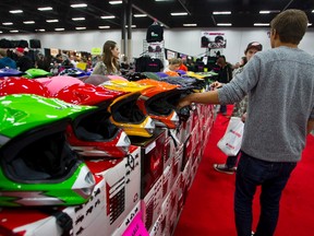 Show attendees check out helmets at the Gateway Powersports booth during the final day of the Edmonton Motorcycle and ATV Show at the Edmonton Expo Centre in Edmonton, Alta., on Sunday, Jan. 19, 2014. Ian Kucerak/Edmonton Sun/QMI Agency