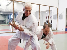 George Zilliax, left, a student at Sudbury Brazilian Jiu-Jitsu and Muay Thai Academy, demonstrates a standing arm lock on head instructor Steve Joncas on Friday. (John Lappa/Sudbury Star)