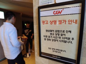 A customer walks by the notice about ‘ransomware’ at CGV theater in Seoul, South Korea, Monday, May 15, 2017. The sign reads “Due to ransomware affection, we are unable to screen advertisement. The movie is going to start 10 minutes after the ticket time.” (AP Photo/Lee Jin-man)