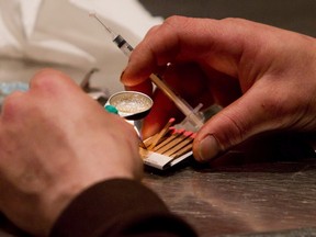 A man prepares heroin he bought on the street to be injected at the Insite safe injection clinic in Vancouver, B.C. THE CANADIAN PRESS/Darryl Dyck