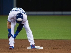Toronto Blue Jays DH Josh Donaldson holds his calf and leaves the game injured while playing against the Baltimore Orioles during an MLB game on April 13, 2017. (THE CANADIAN PRESS/Nathan Denette)