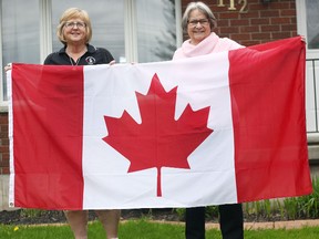 To the left, Maureen Agar and Lin Steffler showcase a Canadian flag last week in Seaforth. Both are part of the Huron East/ Seaforth Community Trust and they are excited to announce that each home owner from Seaforth are slated to receive a Canadian flag, which will be smaller than the one shown in the image. (Shaun Gregory/Huron Expositor)