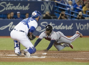 The Braves Adonis Garcia dives into home in the 2nd inning to score the Braves' 3rd run for Atlanta,  as the Toronto Blue Jays host the Atlanta Braves in Toronto, Ont. on Monday May 15, 2017. Stan Behal/Toronto Sun/Postmedia Network