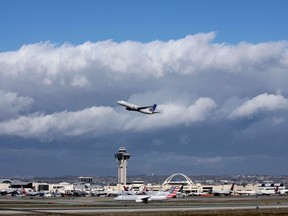 In this Nov. 27, 2016, file photo, a plane flies over Los Angeles International Airport. A $22 million facility at the airport called the Private Suite opened Monday, May 15, 2017, and offers an exclusive entrance, one-on-one security screening and plush lounges. (AP Photo/John Antczak, File)