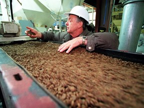 Champion Petfoods founder Reinhard Muhlenfeld checks a conveyor belt of dog food in this 2002 file photo.