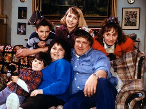 In this undated image released by ABC, shows the cast members of "Roseanne," Michael Fishman as DJ Conner, seated from left, Roseanne Barr as Roseanne Barr, John Goodman as Dan Conner, and second row from left, Sara Gilbert as Darlene Conner, Alicia Goranson as Becky Conner and Laurie Metcalf as Jackie Harris. The original cast of "Roseanne" will return to ABC two decades after it wrapped its hit series, the network said Tuesday in announcing its 2017-18 season plans. (Dan Watson/ABC via AP)