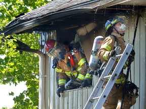 Firefighters work to put out a fire in a townhouse on Ferndale Court Tuesday. A man was taken to hospital after trying to rescue a dog from the fire.(MORRIS LAMONT, The London Free Press)