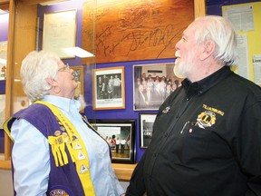 Tillsonburg Lions Club president Vern Fleming (right) and his wife, Terry Fleming, look up at a board stomped on and later signed by Canadian music legend Stompin' Tom Connors during a performance in Tillsonburg in 1990. Among the club's prized possessions, the board was among the memorabilia on display when the club celebrated its 93rd anniversary along with the 100th anniversary of Lions International and the 150th anniversary of Canadian Confederation with an open house social. (JOHN TAPLEY/Postmedia Network)