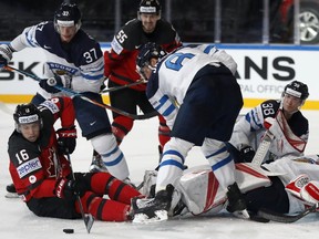 Canada's Mitch Marner tries to control the puck in front of Finland's Harri Sateri during a IIHF Group B match at the AccorHotels Arena in Paris, France on May 16, 2017. (AP Photo/Petr David Josek)