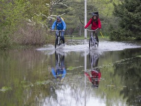 Islanders make there way along a flooded road on Centre Island on Tuesday, May 16, 2017. (STAN BEHAL/TORONTO SUN)