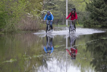 Islanders make there way along a flooded road on Centre Island on Tuesday, May 16, 2017. (STAN BEHAL/TORONTO SUN)