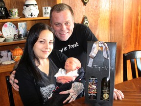 Melissa and Lee Burton are pictured with their sixth child, who they have named Killian Gord Downie Burton, in honour of The Tragically Hip lead singer. They also have some special keepsakes for Killian including an unopened copy of Downie's solo album 'Secret Path,' two bottles of Tragically Hip wine, a program from the final concert as well as their two ticket stubs. (Ellwood Shreve/Postmedia Network)