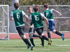 Ernestown Eagles, from left, Arik Sadler (6), Ethan Deline, Adam Doyle (16) and Brady Sadler (4) celebrate Brady Sadler’s late-game goal that gave the Eagles a 2-1 win over the Bayridge Blazers in their opening game of the Kingston Area Secondary Schools Athletic Association senior boys soccer season on Tuesday, April 18. The No. 5 Eagles (5-1-2 including two playoff wins) will meet the No. 2 Kingston Blues (6-1-1) in the championship game on Thursday at Richardson Stadium at 3 p.m. (Tim Gordanier/The Whig-Standard)