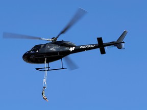 Erendira Vasquez Wallenda hangs from a helicopter as she performs before the start of the NASCAR Sprint Cup series auto race at Charlotte Motor Speedway in Concord, N.C. Oct. 11, 2015. (AP Photo/Terry Renna, File)