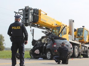 Police investigate after an SUV and a crane collided Tuesday on Elginfield Road northwest of London. The driver of the SUV, Kathryn Kane, 30, of North Middlesex, was pronounced dead at the scene.  (DALE CARRUTHERS / THE LONDON FREE PRESS)
