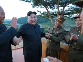 This picture taken on May 14, 2017 and released from North Korea's official Korean Central News Agency (KCNA) on May 15 shows North Korean leader Kim Jong-Un (2nd L) reacting during a test launch of a ground-to-ground medium long-range strategic ballistic rocket Hwasong-12 at an undisclosed location. AFP PHOTO