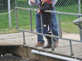 Cole Moffatt is shown in this file photo holding on while Pete Bothwell helps the youngster land a trout at the Bluewater Anglers Fish Hatchery in Point Edward, near Sarnia, Ont., during a previous Kids Training Day. This year's training day is set for May 27. (File photo/ THE OBSERVER)