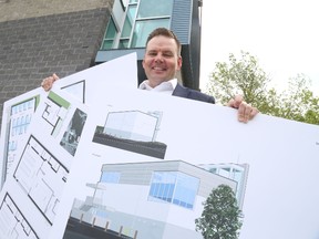 Jason Miller/The Intelligencer
Jodie Jenkins displays artistic renderings of a planned shelter, which will open this fall at the Irish Hall pictured here.