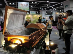 Visitors look at a paper casket at the Asia Funeral and Cemetery Expo & Conference in Hong Kong, Thursday, May 18, 2017. The expo underscores how for some investors, Asia's rapidly aging population makes its death industry a potentially lucrative market. Asia's aging population is projected to hit 923 million by mid-century, according to an Asian Development Bank, putting the region on track to become the oldest in the world. (AP Photo/Vincent Yu)