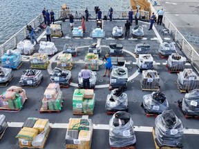 This image made available by the U.S. Coast Guard, shows members of the media, gathered around pallets of seized cocaine, at a news conference, Thursday, May 18, 2017 at Port Everglades in Fort Lauderdale, Fla. (U.S. Coast Guard via AP)