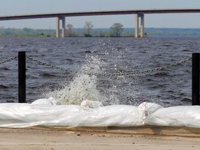 Water splashes over a flood barrier along the Bay of Quinte at Meyers Pier Thursday, May 18, 2017 in Belleville, Ont. More flood precautions are being taken in the area. Luke Hendry/Belleville Intelligencer/Postmedia Network