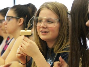 Katie Allingham, a Grade 10 St. Patrick's school student, admires her handiwork threading wires during a lamp-building exercise at Lambton College Thursday. Allingham was one of about 100 female high school students taking part in the annual Women in Skilled Trades Day.  (Tyler Kula/Sarnia Observer)