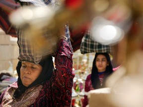 Women carry their shopping at a popular Ramadan lantern market in Cairo on May 15 as they prepare for the holy month of Ramadan. (Amr Nabil/The Associated Press)