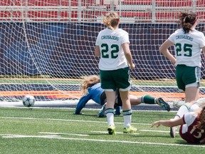 Chloe Cabral of the Regiopolis-Notre Dame Panthers (13) ends up on the turf after scoring her team's first goal in a 2-1 victory over the Holy Cross Crusaders in the Kingston Area Secondary Schools Athletic Association senior girls soccer final Thursday at Richardson Stadium. Watching the ball enter the net are Crusaders keeper Jacqueline van Herpt, Denielle Benton (22) and Sydney Gauthier (25). (Tim Gordanier/The Whig-Standard)